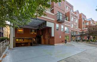 A red brick building with a black awning and a black metal basket hanging from it.