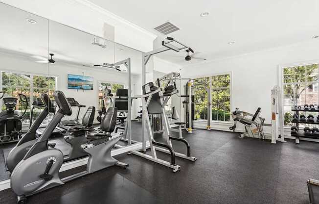 A spacious gym with a variety of equipment including treadmills, stationary bikes, and weight machines.