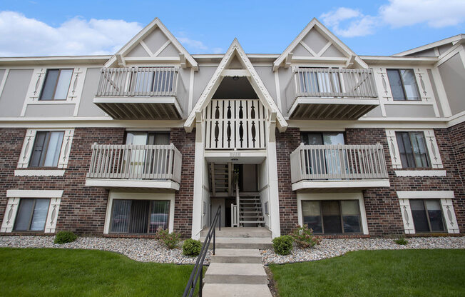 Exterior brick apartment building with balconies and grass