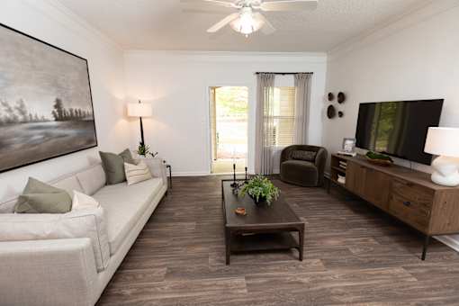A living room with a white couch, a coffee table, and a painting on the wall.