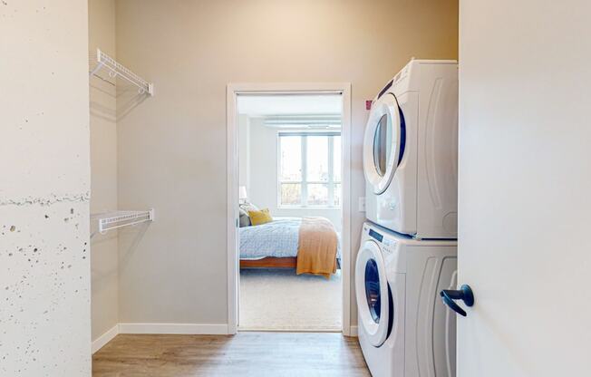 a bedroom with a large window and a washer and dryer