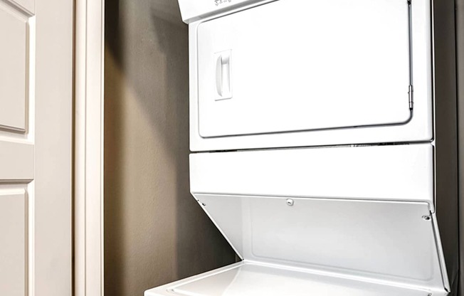 a white washer and dryer in a kitchen with a door