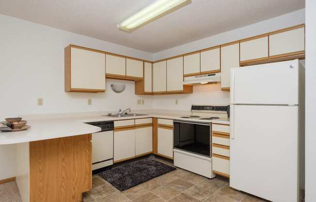 a kitchen with black and white appliances. Fargo, ND Twin Parks Apartments.