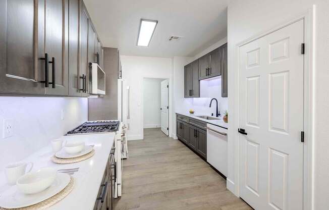 a kitchen with white cabinets and a long counter top