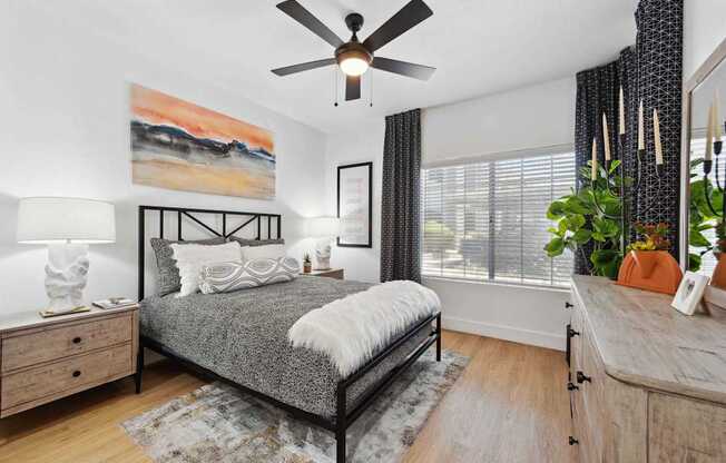 A bedroom with a bed, dresser, and ceiling fan.