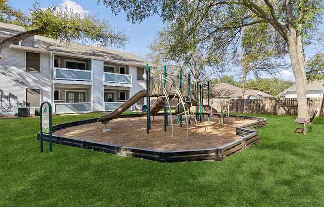 A playground with a slide and swings in a backyard.