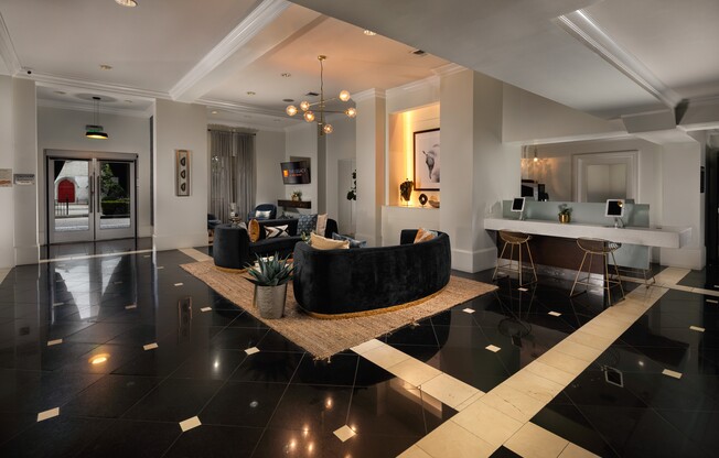 A black and white tiled floor with a round black couch in the middle.