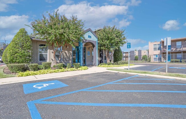 The leasing office parking lot with a disabled parking sign painted on the pavement at The Drake in Bossier City, LA