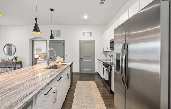 A modern kitchen with a large island and stainless steel appliances.