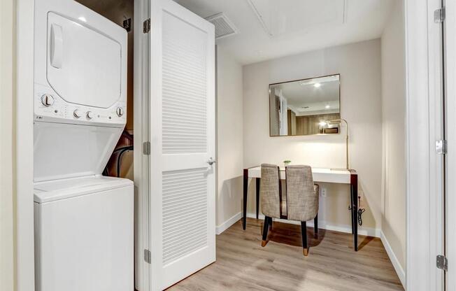 a washer and dryer in a laundry room with a desk and a mirror