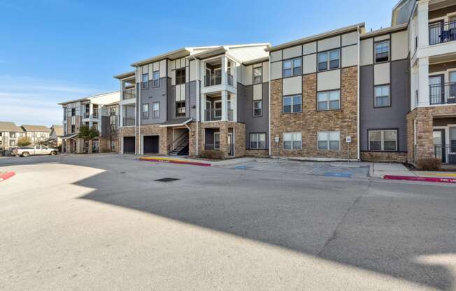 an empty parking lot in front of an apartment building