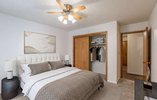 a bedroom with a bed and a ceiling fan. Fargo, ND Betty Ann Apartments