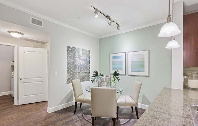 A dining room with a glass table and chairs.