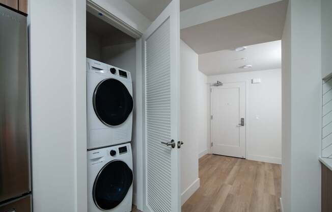 A laundry room with a washer and dryer stacked on top of each other.