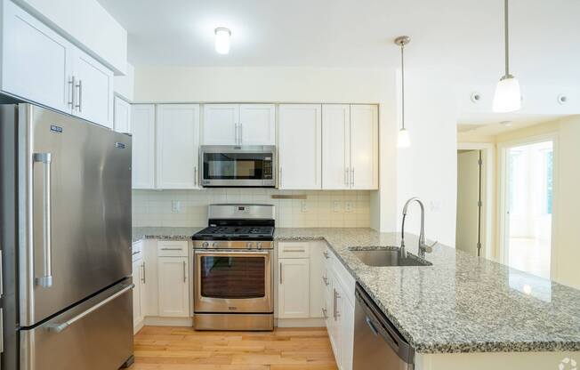 A kitchen with a granite countertop and stainless steel appliances at 603 Concord Apartments, Massachusetts