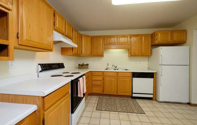 A kitchen with white appliances. Pinehurst Apartments