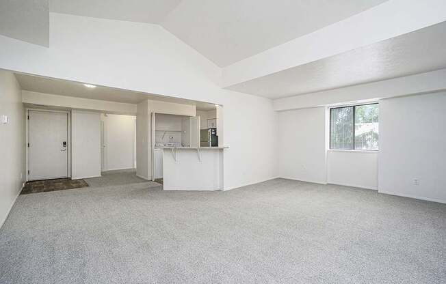 End living and dining room with a high ceiling and carpet at Foxwood and The Hermitage in Portage, MI