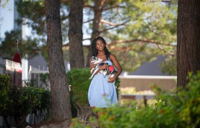 A woman in a blue dress is walking through a garden.
