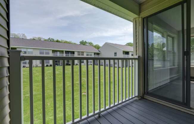 a view of a yard from a balcony with a sliding glass door