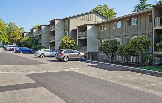 A parking lot with cars and apartment buildings in the background.