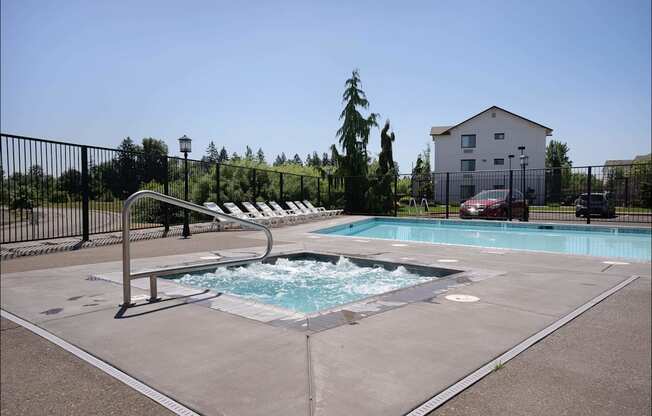 A small pool with a slide and a house in the background at Riverplace Apartment Homes, Independence, OR, 97351