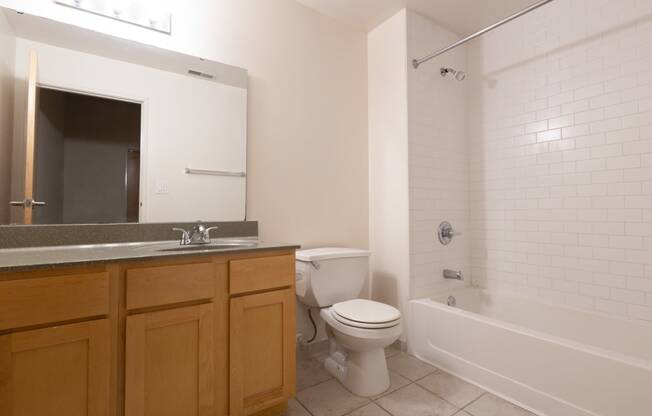 a bathroom with a toilet sink and bathtub at 26 West, Managed by Buckingham Urban Living, Indianapolis