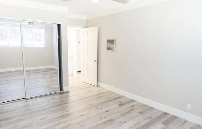 an empty room with white walls and a sliding glass door