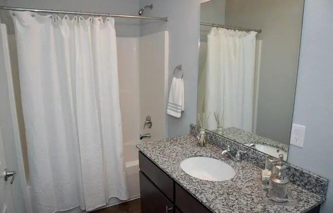 a bathroom with a white shower curtain and a sink