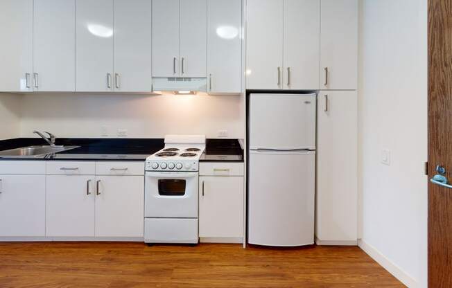 a kitchen with white cabinets and white appliances