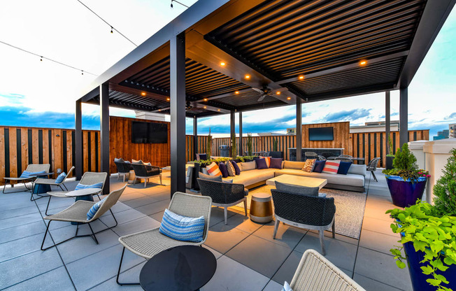 a roof top patio with a couch and chairs