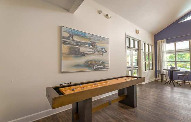 a game room with a pool table and a painting on the wall
