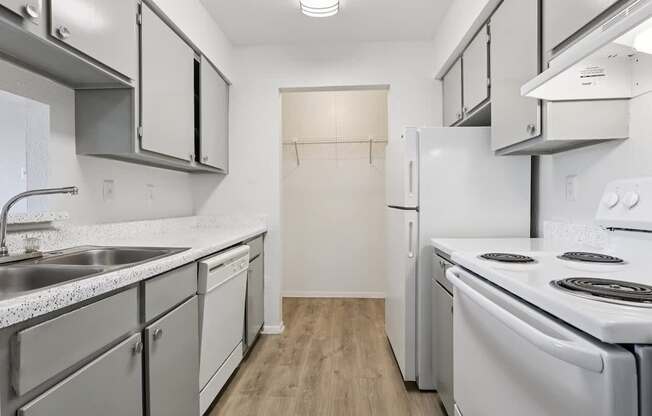 A kitchen with white appliances and cabinets.