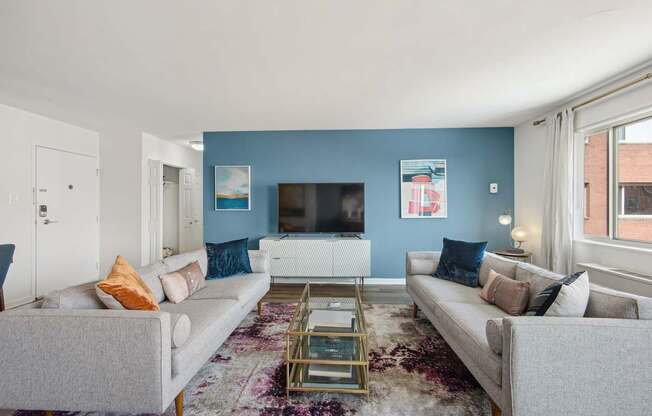 A living room with a grey couch, a coffee table, and a flat screen TV.