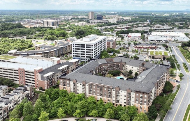 A large building complex with a parking garage in front.