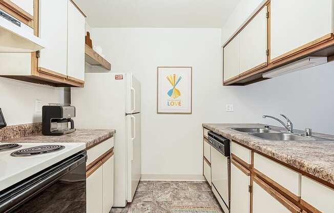 A galley style kitchen with a dishwasher at Tanglewood Apartments, Oak Creek