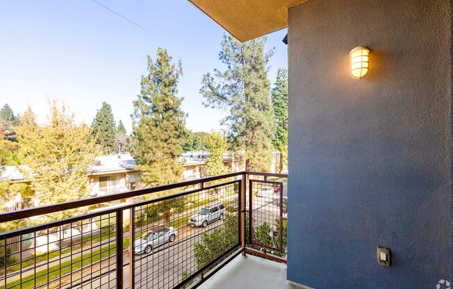 A balcony with a metal railing and a light on the wall.
