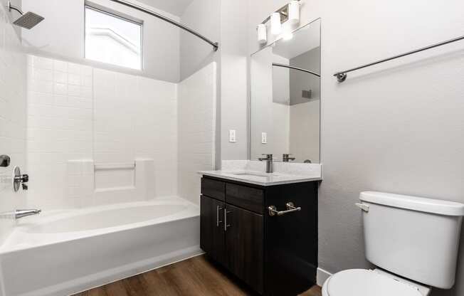 a bathroom with a toilet and a sink and a bath tub