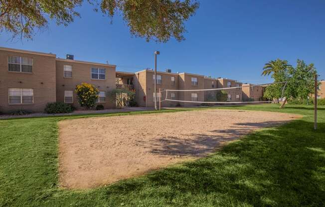 A sandy area in front of apartment buildings.