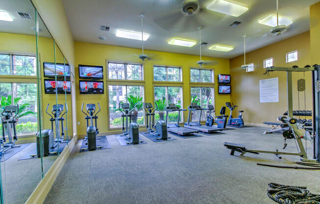 spacious gym with cardio equipment and windows at the estates apartments