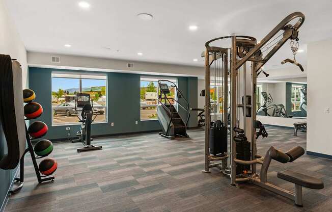 A gym with a variety of equipment including a leg press machine, a chest press machine, and a squat rack.