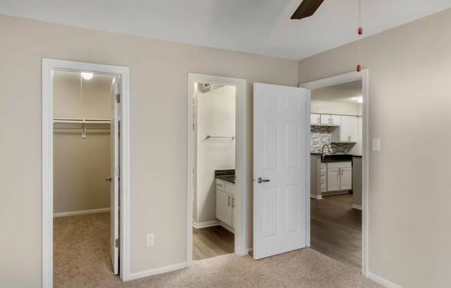 Carpet bedroom with en suite bathroom, two tone paint, ceiling fan and entrance to closet