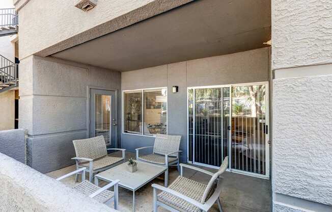 A patio with a table and chairs is on the balcony of a house.