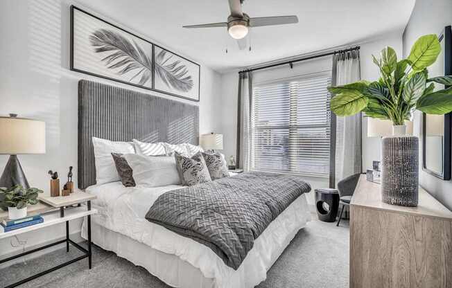 A bedroom with a large bed and a ceiling fan.