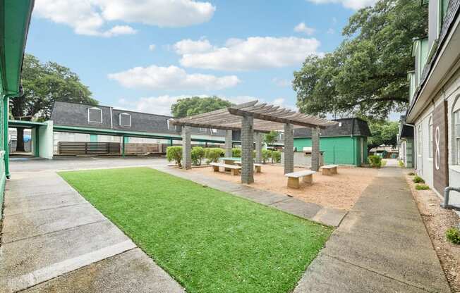 a courtyard with a picnic area and a green building