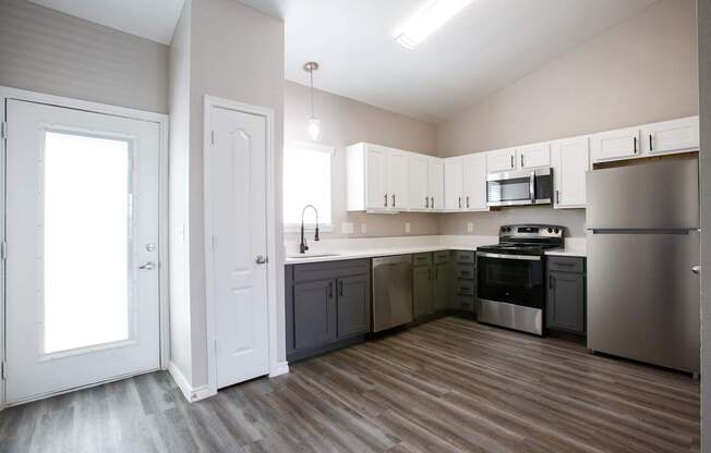 A kitchen with white cabinets and stainless steel appliances.
