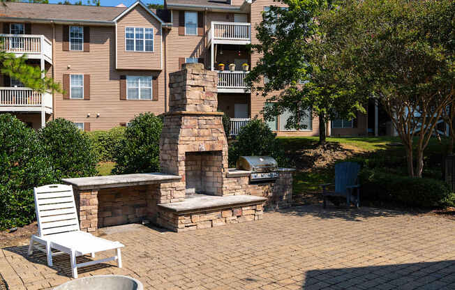 A patio with a fireplace and chairs.