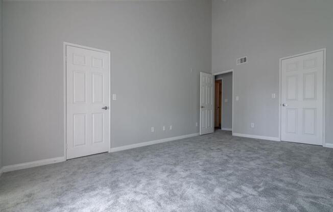 a bedroom with a carpeted floor and two doors at Warner Center Townhomes, California