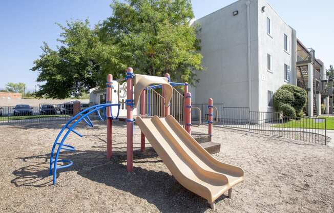a playground with a slide in front of a building