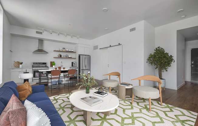 a living room with a blue couch and a green and white rug