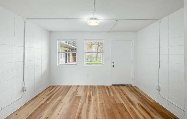 an empty room with white walls and wood floors at The Courts Midtown, Memphis, TN